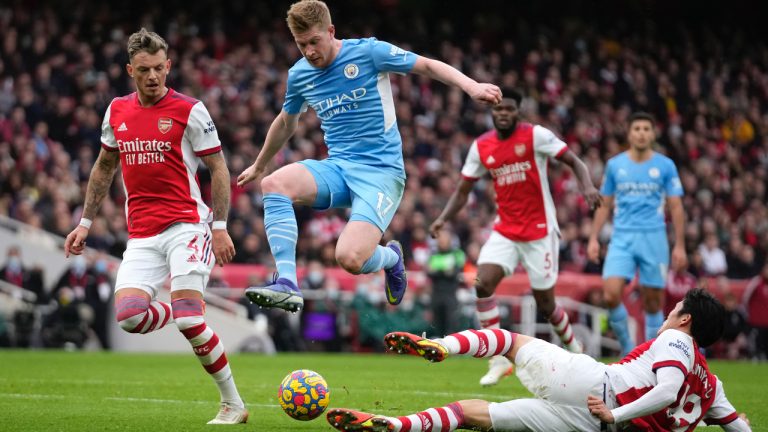 Arsenal's Takehiro Tomiyasu, right, challenges Manchester City's Kevin De Bruyne during the Premier League soccer match between Arsenal and Manchester City at the Emirates Stadium, in London, England, Saturday Jan. 1, 2022. (Matt Dunham/AP)