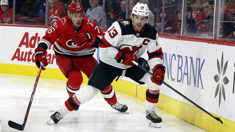 New Jersey Devils' Nico Hischier (13) controls the puck with Carolina Hurricanes' Brady Skjei closing in during the third period of an NHL hockey game in Raleigh, N.C., Tuesday, Dec. 20, 2022. (Karl B DeBlaker/AP)