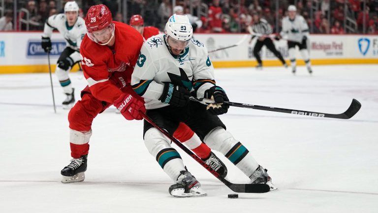 Detroit Red Wings defenseman Gustav Lindstrom (28) defends San Jose Sharks left wing Matt Nieto (83) in the third period of an NHL hockey game Tuesday, Jan. 4, 2022, in Detroit. (Paul Sancya/AP)