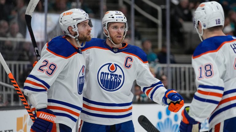 Edmonton Oilers centre Connor McDavid, middle, celebrates with centre Leon Draisaitl, left, and left wing Zach Hyman after scoring against the San Jose Sharks during the second period of an NHL hockey game in San Jose, Calif., Friday, Jan. 13, 2023. (Godofredo A. Vásquez/AP)