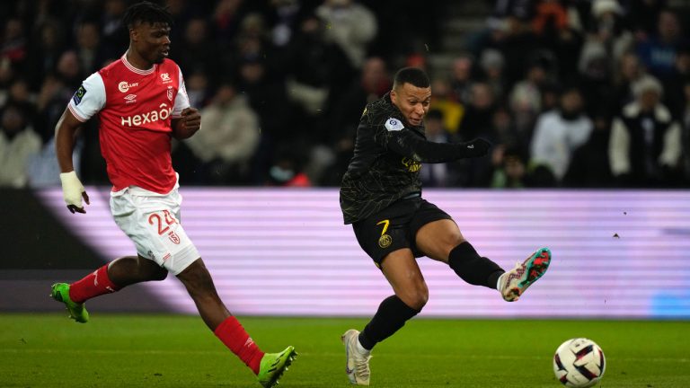 Reims' Emmanuel Agbadou, left, tries to block a shot from PSG's Kylian Mbappe during the French League One soccer match between Paris Saint-Germain and Reims at the Parc des Princes in Paris, Sunday, Jan. 29, 2023. (Thibault Camus/AP)