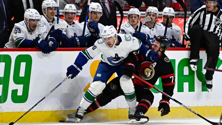 Vancouver Canucks left wing Tanner Pearson (70) keeps Ottawa Senators defenceman Thomas Chabot (72) away from the puck as they skate along the Canucks bench during third period NHL hockey action in Ottawa, on Tuesday, Nov. 8, 2022. (Justin Tang/CP)