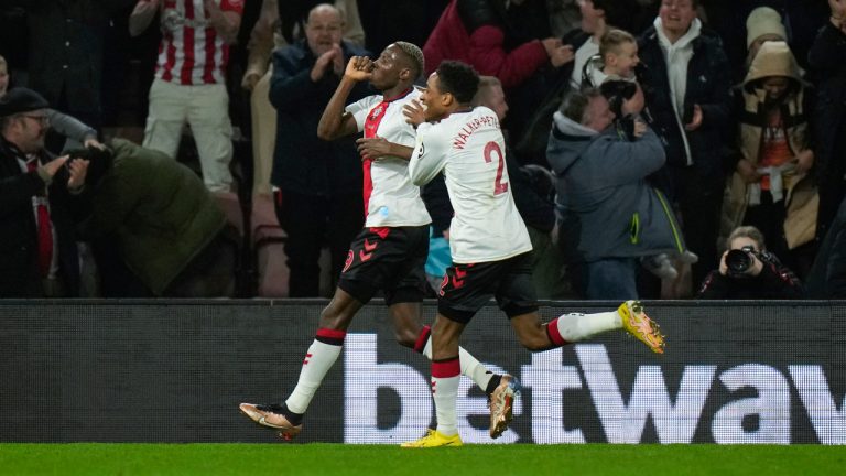 Southampton's Moussa Djenepo, left, celebrates with teammate Kyle Walker-Peters after scoring his side's second goal during the English League Cup quarter final soccer match between Southampton and Manchester City at St Mary's stadium in Southampton, England, Wednesday, Jan. 11, 2023. (Alastair Grant/AP)