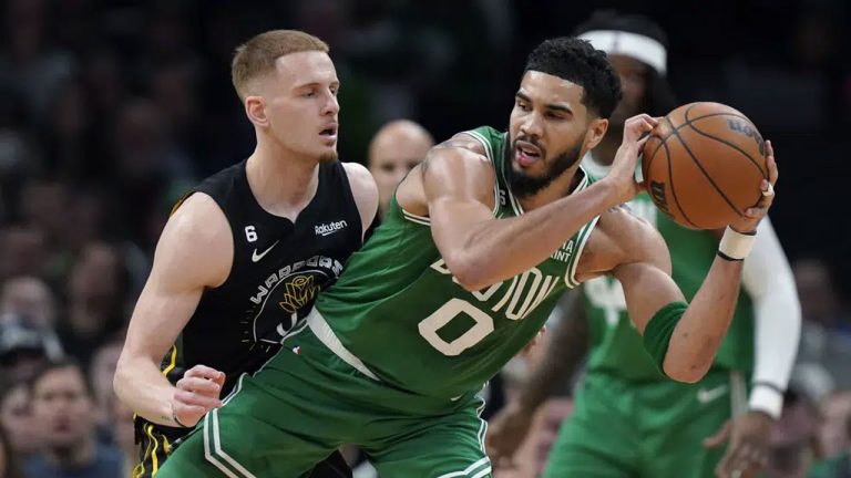 Boston Celtics forward Jayson Tatum (0) looks for an opening around Golden State Warriors guard Donte DiVincenzo, left, in the first half of an NBA basketball game. (Steven Senne/AP)
