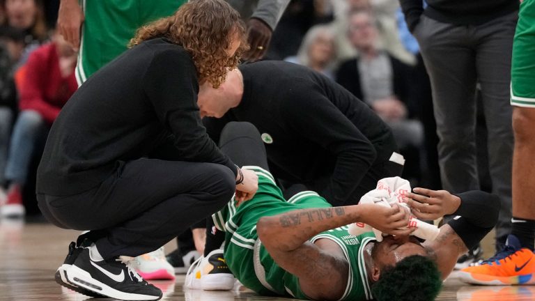 Trainers tend to Boston Celtics guard Marcus Smart (36) after an injury during first half NBA basketball action against the Toronto Raptors. (Frank Gunn/CP)