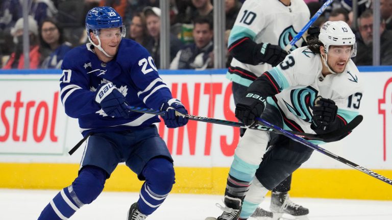 Toronto Maple Leafs left wing Dryden Hunt (20) and Seattle Kraken left wing Brandon Tanev (13) battle at mid-ice during first period NHL hockey action. (Frank Gunn/CP)