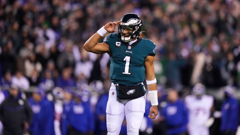 Philadelphia Eagles quarterback Jalen Hurts reacts after throwing a touchdown pass to wide receiver DeVonta Smith during the first half of an NFL divisional round playoff football game against the New York Giants. (Matt Slocum/AP)