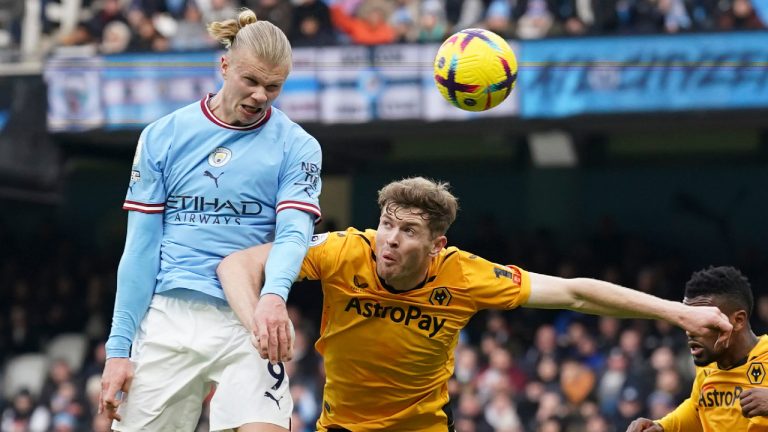 Manchester City's Erling Haaland, left, heads the ball to score his side's opening goal during the English Premier League soccer match between Manchester City and Wolverhampton at the Etihad Stadium in Manchester, England, Sunday, Jan. 22, 2023. (Dave Thompson/AP) 