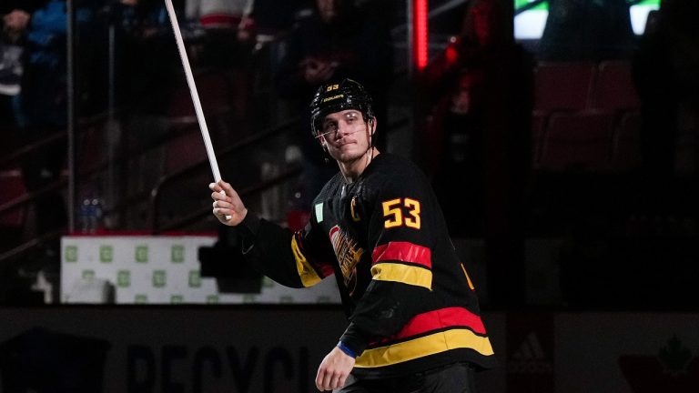 Vancouver Canucks' Bo Horvat skates to toss a stick into the crowd after being named the first star of an NHL hockey game against the Columbus Blue Jackets in Vancouver, on Friday, January 27, 2023.