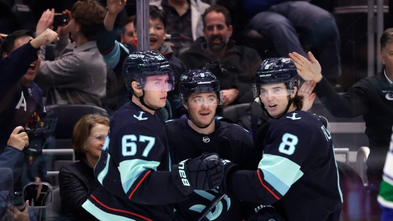 Seattle Kraken center Morgan Geekie (67), center Ryan Donato and defenseman Cale Fleury (8) celebrate Donato's goal against the Vancouver Canucks during the third period of an NHL hockey game Wednesday, Jan. 25, 2023, in Seattle. The Kraken won 6-1. (John Froschauer/AP Photo)