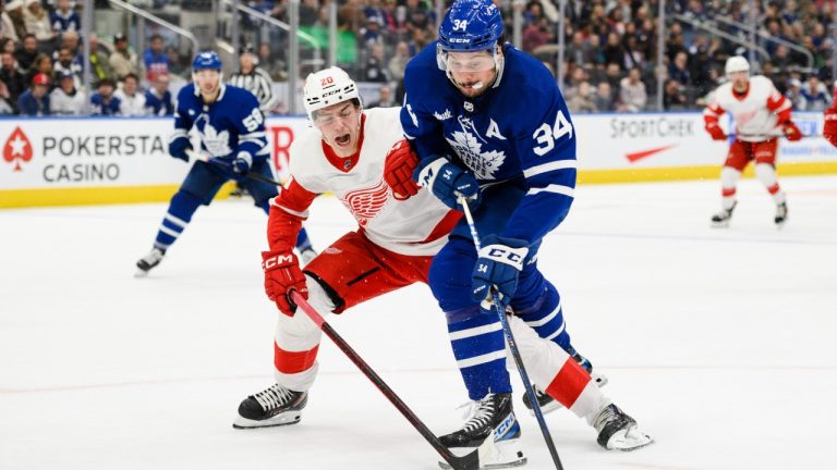 Toronto Maple Leafs centre Auston Matthews (34) is defended by Detroit Red Wings defenceman Albert Johansson (20) during second period NHL pre-season action, in Toronto, on Saturday, October 8, 2022. (Christopher Katsarov/CP)