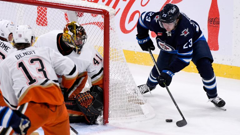 Anaheim Ducks goaltender Anthony Stolarz (41) guards the goal as Winnipeg Jets' Mikey Eyssimont (23) carries the puck around the net during second period NHL action in Winnipeg on Sunday, December 4, 2022. (Fred Greenslade/CP)