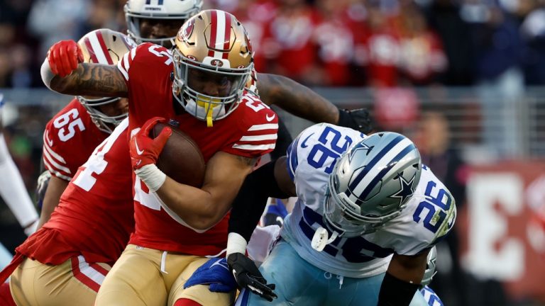 San Francisco 49ers running back Elijah Mitchell, left, runs against Dallas Cowboys cornerback DaRon Bland (26) during the first half of an NFL divisional round playoff football game in Santa Clara, Calif., Sunday, Jan. 22, 2023. (Josie Lepe/AP)