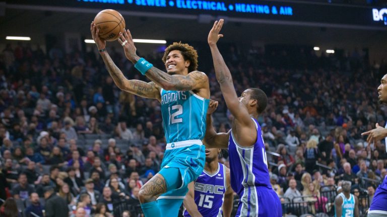 Charlotte Hornets guard Kelly Oubre Jr. (12) lays the ball up past Sacramento Kings forward Harrison Barnes during the first quarter of an NBA basketball game in Sacramento, Calif., Monday, Dec. 19, 2022. (Randall Benton/AP)