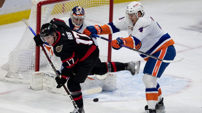 New York Islanders defenceman Samuel Bolduc clears Ottawa Senators forward Ridly Greig from in front of goaltender Semyon Varlamov during first period NHL action. (Adrian Wyld/CP)