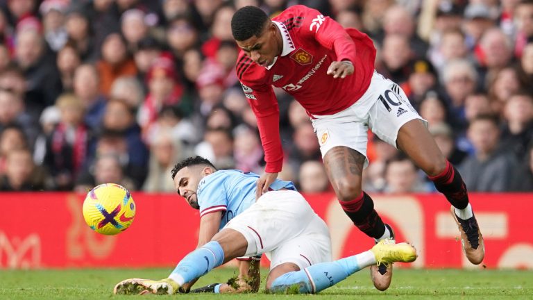 Manchester United's Marcus Rashford, right, challenges for the ball with Manchester City's Riyad Mahrez during the English Premier League soccer match between Manchester United and Manchester City at Old Trafford in Manchester, England, Saturday, Jan. 14, 2023. (Dave Thompson/AP) 