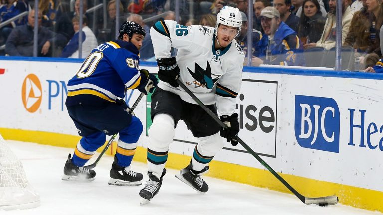 San Jose Sharks' Jasper Weatherby (26) controls the puck while under pressure from St. Louis Blues' Ryan O'Reilly (90) during the first period of an NHL hockey game Thursday, Nov. 18, 2021, in St. Louis. (Scott Kane/AP)