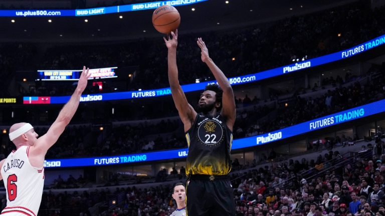 Golden State Warriors forward Andrew Wiggins, right, shoots over Chicago Bulls guard Alex Caruso during the first half of an NBA basketball game in Chicago, Sunday, Jan. 15, 2023.