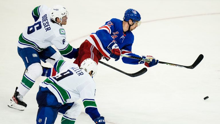 New York Rangers' Filip Chytil (72) drives past Vancouver Canucks' Brock Boeser (6) and J.T. Miller (9) during the third period of an NHL hockey game Wednesday, Feb. 8, 2023, in New York. (Frank Franklin II/AP)