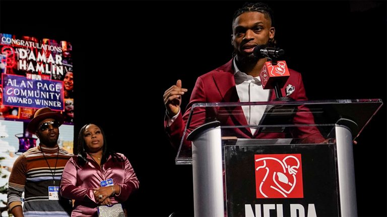 Buffalo Bills' Damar Hamlin, right, speaks after being introduced as the winner of the Alan Page Community Award during a news conference ahead of the Super Bowl 57 Wednesday, Feb. 8, 2023, in Phoenix. At left looking on are Damar Hamlin's parents Mario and Nina Hamlin. (Mike Stewart/AP)