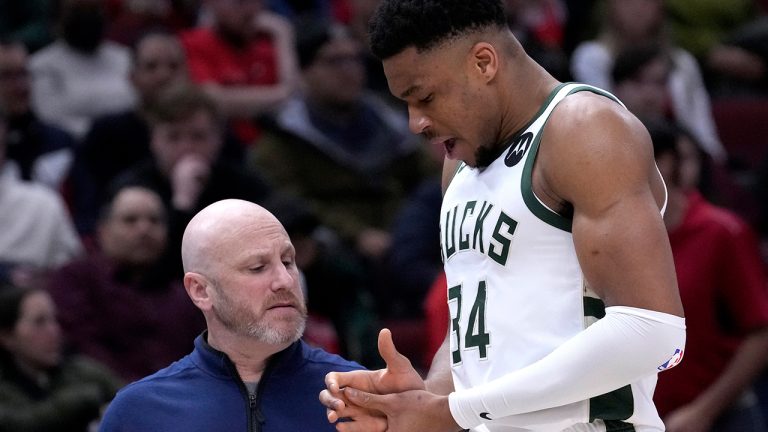 Milwaukee Bucks' Giannis Antetokounmpo holds his injured right hand as he and a member of the medical staff head to the locker room during the first half of the team's NBA basketball game against the Chicago Bulls on Thursday, Feb. 16, 2023, in Chicago. (Charles Rex Arbogast/AP)