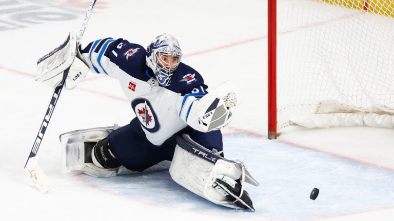 Winnipeg Jets goaltender Connor Hellebuyck (37) makes a glove-save during the third period of an NHL hockey game against the Buffalo Sabres, Thursday, Jan. 12, 2023, in Buffalo, N.Y. (Jeffrey T. Barnes/AP Photo)