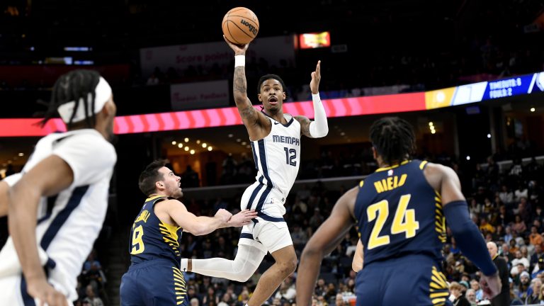 Memphis Grizzlies guard Ja Morant (12) passes the ball over Indiana Pacers guard T.J. McConnell (9) in the first half of an NBA basketball game Sunday, Jan. 29, 2023, in Memphis, Tenn. (Brandon Dill/AP)