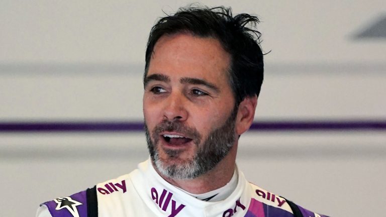 In this Jan. 23, 2021, file photo, Jimmie Johnson interacts with crew members in his garage during a practice session for the Rolex 24 hour auto race at Daytona International Speedway in Daytona Beach, Fla. The first season on Johnson's midlife career change closes Sunday, Sept. 26, 2021, with the IndyCar season finale, a week after his strongest moments yet through 11 races in a brand new discipline. (John Raoux/AP)