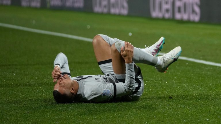 Injured PSG's Kylian Mbappe grimaces in pain during the French League One soccer match between Montpellier and Paris Saint-Germain at the State La Mosson stadium in Montpellier, France, Wednesday, Feb. 1, 2023. (Thibault Camus/AP)