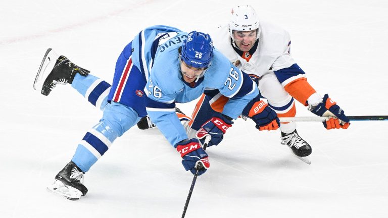 New York Islanders' Adam Pelech (3) and Montreal Canadiens' Johnathan Kovacevic battle for the puck during first period NHL hockey action in Montreal, Saturday, February 11, 2023. (Graham Hughes/CP)