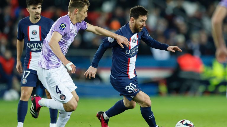 PSG's Lionel Messi, right, runs with the ball next to Toulouse's Anthony Rouault during the French League One soccer match between Paris Saint-Germain and Toulouse, at the Parc des Princes, in Paris, France, Saturday, Feb. 4, 2023. (Lewis Joly/AP)