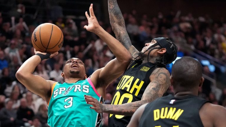 San Antonio Spurs forward Keldon Johnson (3) goes to the basket as Utah Jazz guard Jordan Clarkson (00) defends during the first half of an NBA basketball game Saturday, Feb. 25, 2023, in Salt Lake City. (Rick Bowmer/AP)