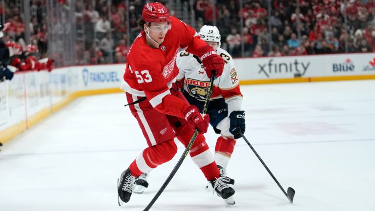 Detroit Red Wings defenseman Moritz Seider (53) shoots as Florida Panthers center Sam Reinhart (13) defends in the third period of an NHL hockey game Friday, Jan. 6, 2023, in Detroit. (Paul Sancya/AP)