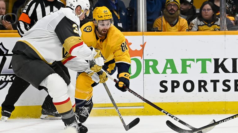 Nashville Predators center Tommy Novak reaches for the puck as Vegas Golden Knights defenseman Brayden McNabb defends during the second period of an NHL hockey game Tuesday, Feb. 7, 2023, in Nashville, Tenn. (Mark Zaleski/AP)