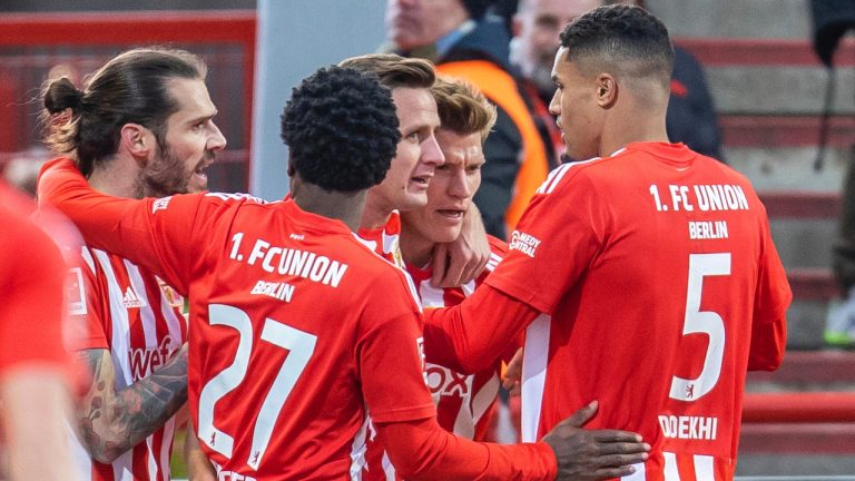 Berlin players celebrate after the opening goal against goalkeeper Finn Dahmen, left, of FSV Mainz 05 during the German Bundesliga soccer match between Union Berlin and FSV Mainz 05 in Berlin, Germany, Saturday, Feb.4, 2023. (Andreas Gora/dpa via AP)