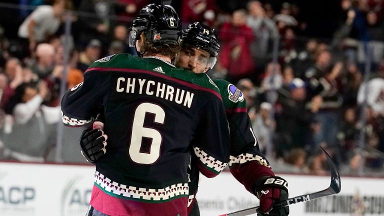 Arizona Coyotes' Shayne Gostisbehere (14), right, is hugged by teammate Jakob Chychrun (6) after scoring a goal against the Buffalo Sabres in the first period during an NHL hockey game. (Darryl Webb/AP)