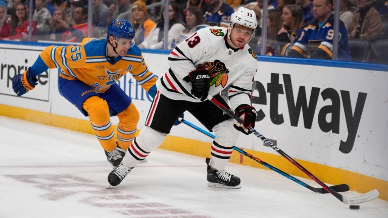 Chicago Blackhawks' Max Domi (13) handles the puck as St. Louis Blues' Colton Parayko (55) defends during the first period of an NHL hockey game Thursday, Dec. 29, 2022, in St. Louis. (Jeff Roberson/AP)