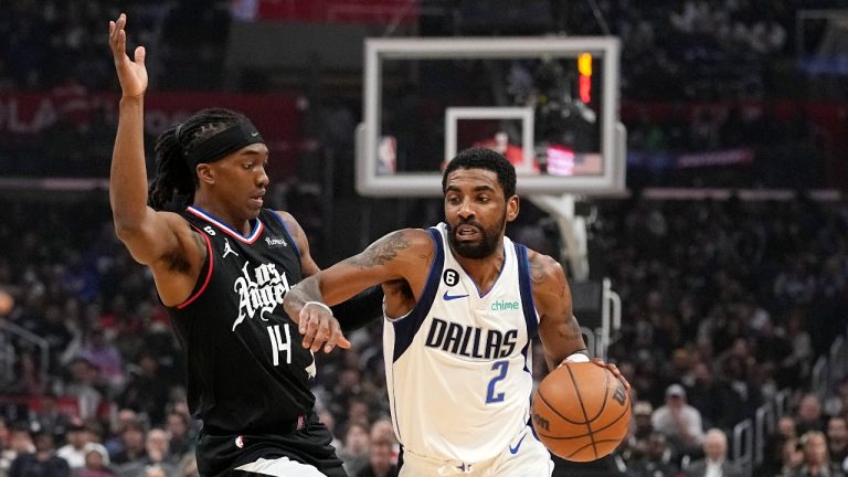 Dallas Mavericks guard Kyrie Irving, right, drives past Los Angeles Clippers guard Terance Mann during the first half of an NBA basketball game Wednesday, Feb. 8, 2023, in Los Angeles. 