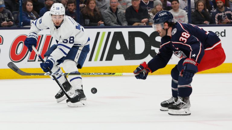 Toronto Maple Leafs' Michael Bunting, left, passes the puck in front of Columbus Blue Jackets' Boone Jenner during the first period of an NHL hockey game Monday, March 7, 2022, in Columbus, Ohio. (Jay LaPrete/AP)