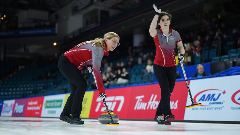 Northwest Territories fourth Jo-Ann Rizzo, left, sweeps as second Sarah Koltun gestures to skip Kerry Galusha while playing Newfoundland & Labrador at the Scotties Tournament of Hearts, in Kamloops, B.C. (Darryl Dyck/CP)