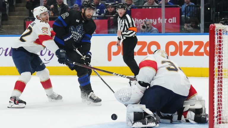 Florida Panthers goaltender Alex Lyon (34) stops a shot from Toronto Maple Leafs forward Zach Aston-Reese (12) as Panthers defenceman Gustav Forsling (42) defends during second period NHL hockey action in Toronto on Wednesday, March 29, 2023. (Nathan Denette/CP)