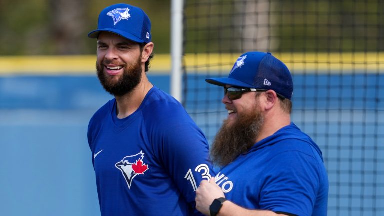 Toronto Blue Jays first baseman Brandon Belt, left, smiles as he talks with a member of the Blue Jays training staff during baseball spring training in Dunedin, Fla., on Tuesday, February 21, 2023. (Nathan Denette/CP)