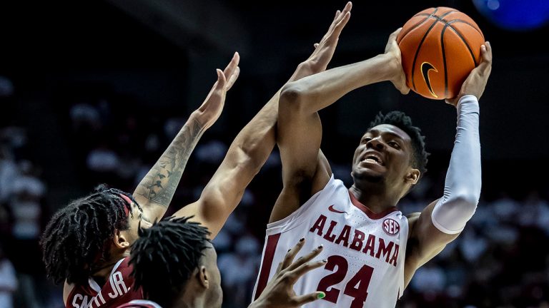 Alabama forward Brandon Miller (24) fires off a shot with Arkansas guard Nick Smith Jr. (3) and guard Davonte Davis (4) defending during the second half of an NCAA college basketball game, Saturday, Feb. 25, 2023, in Tuscaloosa, Ala. (Vasha Hunt/AP)