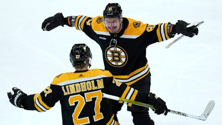 Boston Bruins defenseman Dmitry Orlov, top, is congratulated by Hampus Lindholm (27) after his goal against the Buffalo Sabres during the second period of an NHL hockey game, Thursday, March 2, 2023, in Boston. (AP Photo/Charles Krupa)