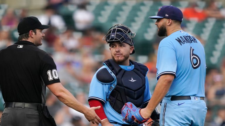 Home plate umpire Adam Beck talks with Toronto Blue Jays catcher Alejandro Kirk and starting pitcher Alek Manoah during a game in 2021. The rule changes will have an impact on how pitchers and catcher communicate this season. (Carlos Osorio/AP) 