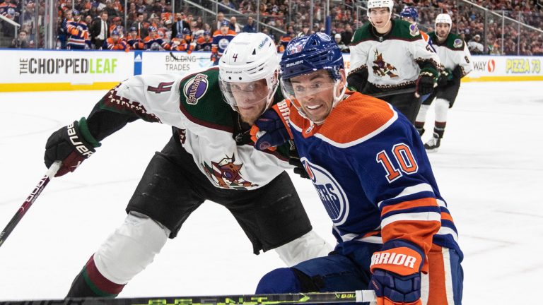 Arizona Coyotes' Juuso Valimaki (4) and Edmonton Oilers' Derek Ryan (10) battle for the puck during second period NHL action in Edmonton on Wednesday March 22, 2023. (Jason Franson/CP)