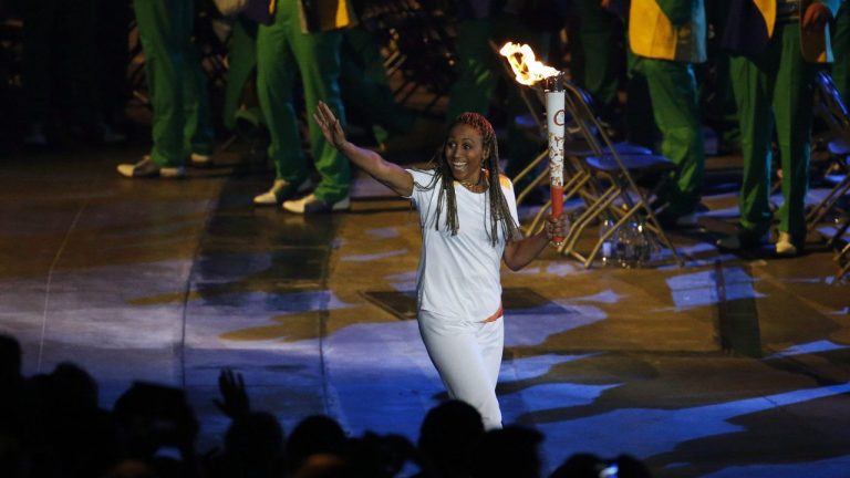 Charmaine Crooks carries the Pan Am flame during the opening ceremony of the 2015 Pan Am Games in Toronto. (Julio Cortez/AP)
