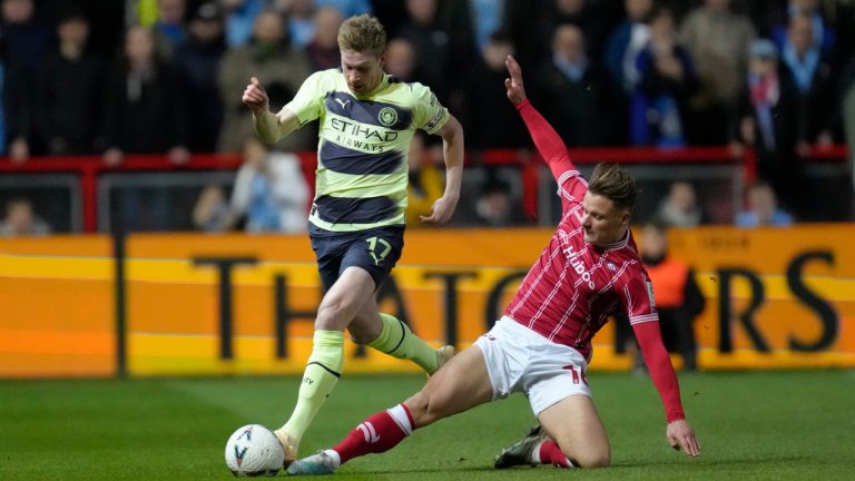 Manchester City's Kevin De Bruyne, left, is tackled by Bristol City's Cameron Pring during the English FA Cup fifth round soccer match between Bristol City and Manchester City at Ashton Gate stadium in Bristol, England, Tuesday, Feb. 28, 2023. (Kirsty Wigglesworth/AP)