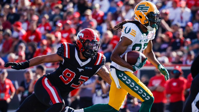 Edmonton Elks receiver Derel Walker, right, runs the ball as Calgary Stampeders defensive lineman Romeo McKnight, grabs for him during second half CFL football action in Calgary, Alta., Monday, Sept. 5, 2022.(Jeff Mcintosh/CP)