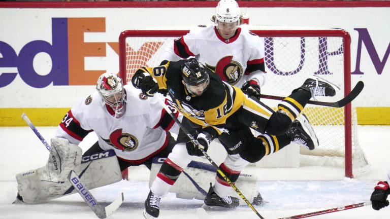 Pittsburgh Penguins' Jason Zucker (16) is checked to the ice by Ottawa Senators' Jakob Chychrun (6) in front of goaltender Dylan Ferguson (34) during the first period of an NHL hockey game in Pittsburgh, Monday, March 20, 2023. (Gene J. Puskar/AP)